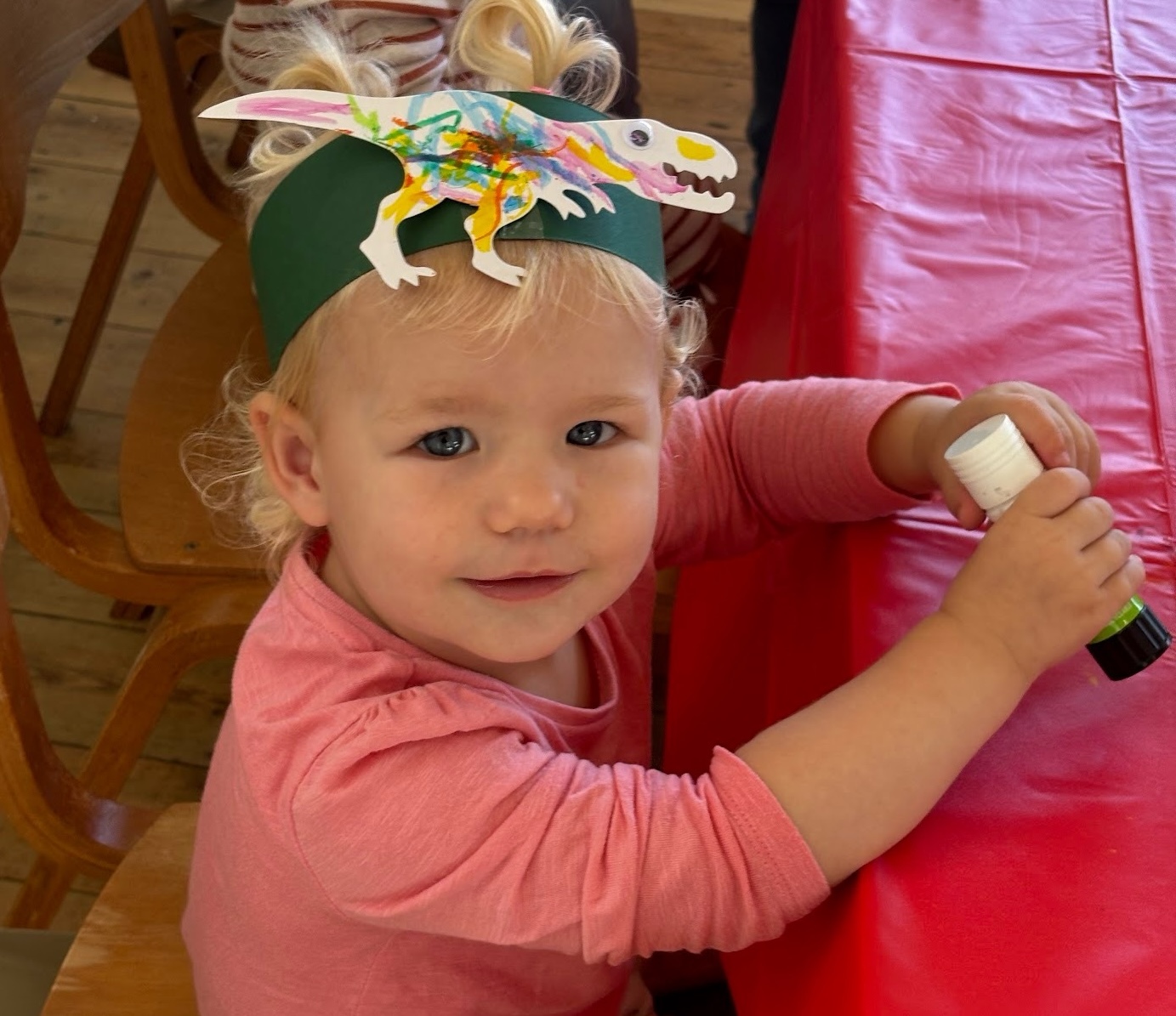 Child wearing a handmade dinosaur headband at Happy Little Makers
